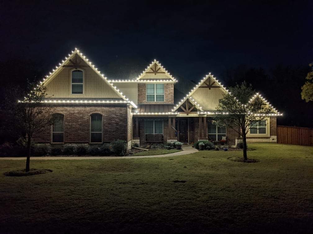 Home outlined in holiday lights at night